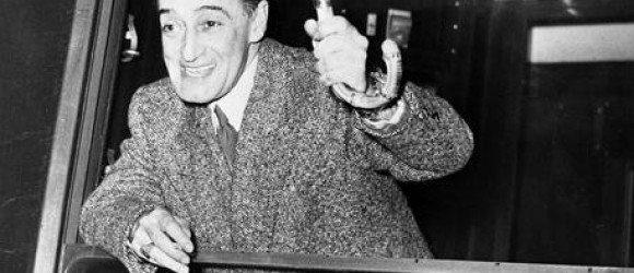 Antonio De Curtis in arte Totò, uno dei comici più amati di tutti i tempi, saluta i fans dal finestrino del vagone di un treno appena giunto alla stazione di Parigi in una immagine del 1951.  Figlio illegittimo del principe Giuseppe De Curtis e della giovane Anna Clemente, che solo nel 1921 riusciranno a sposarsi, Toto' nasce a Napoli nel 1898. Registrato con  il cognome materno, verra' riconosciuto come figlio dal principe soltanto nel 1941 e solo nel 1946, morto il Principe De Curtis, il Tribunale lo autorizza a fregiarsi del titolo di Antonio Griffo Focas Flavio Angelo Ducas Commeno Porfirogenito Gagliardi De Curtis di Bisanzio, Altezza Imperiale, Conte Palatino, Cavaliere del Sacro Romano Impero,...   E' la madre a dargli il nomignolo di Toto'.   ANSA